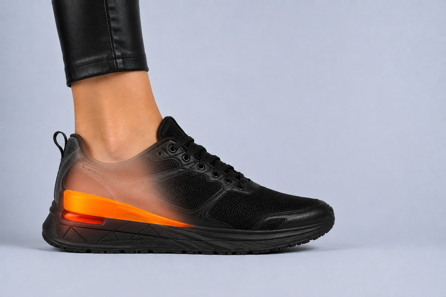 Cutaway view of the same trainer showing the orange height-increase insole wedge lifting the heel inside the shoe